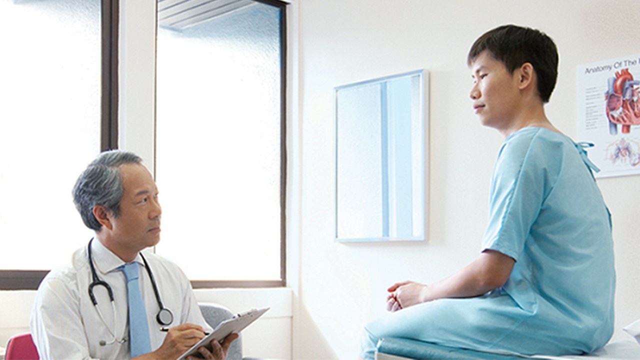 一位男士在与医生交谈；图片使用于介绍“汇丰新加坡早期重大疾病保险计划”
