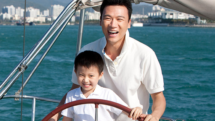 A father on a boat with his son; image used for HSBC Singapore Investments