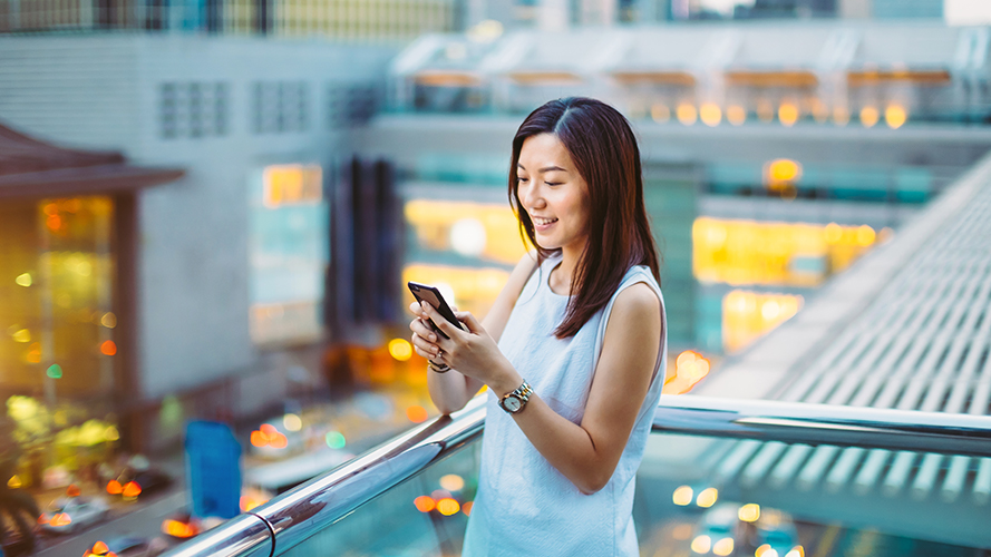 Using mobile phone in cafe; image used for HSBC Singapore PayNow page.