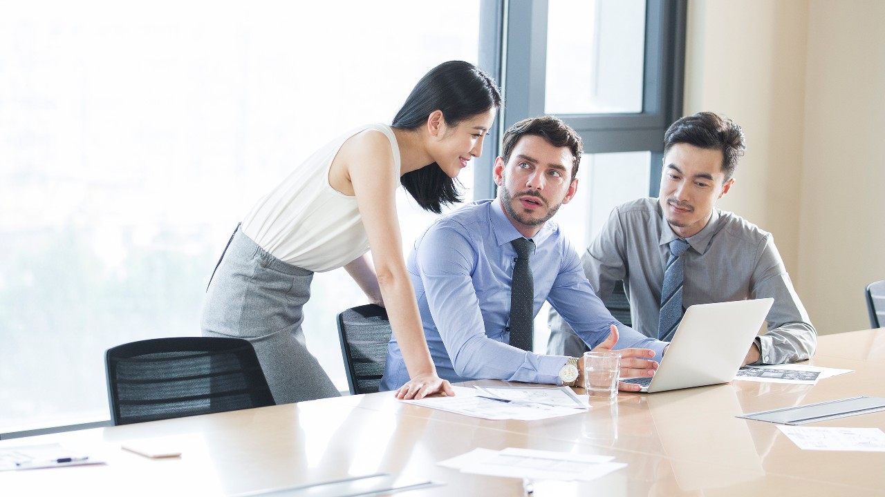 Business people talking in meeting room; image used for HSBC Singapore expat article Work passes and visas.