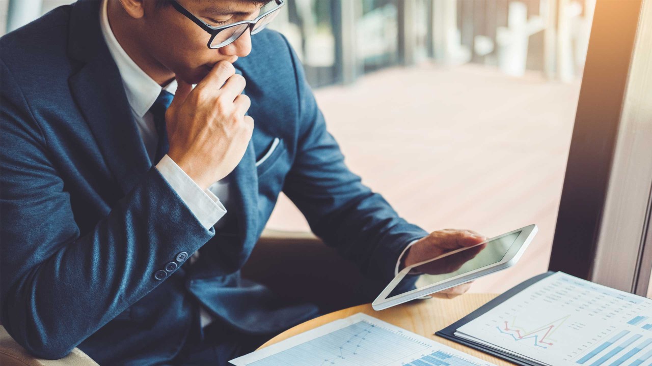 Businessman working and using Digital Tablet on finance investment.