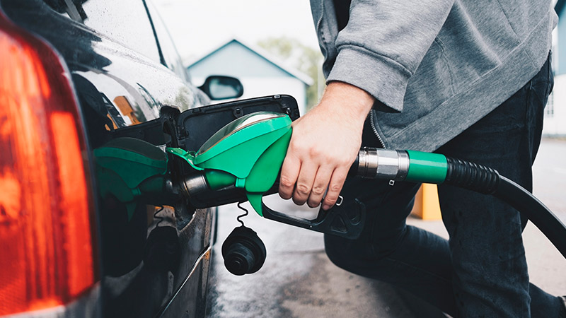 A man is filling up gasoline for his car