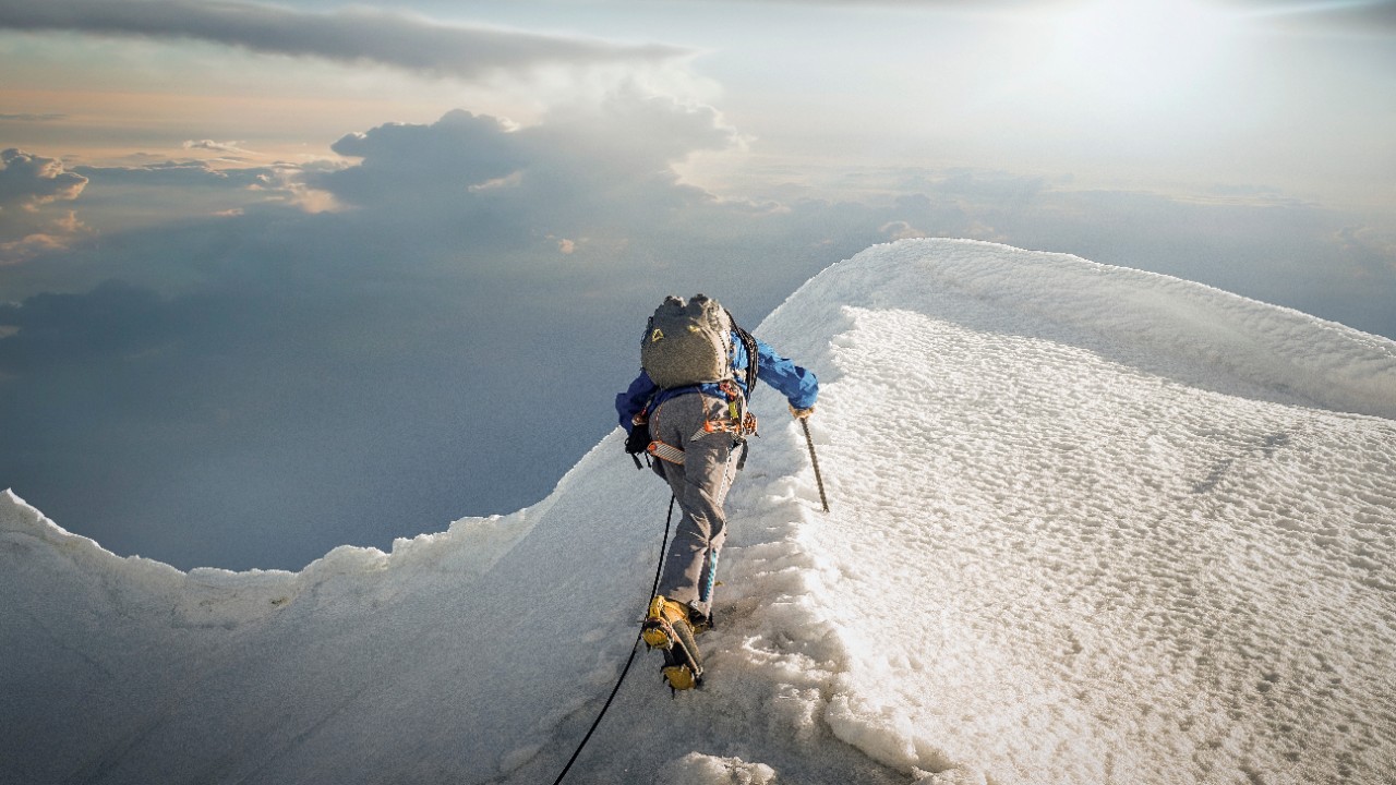 Climber on snowy mountain ridge; image used for HSBC Singapore article Practical tips for successful investing.