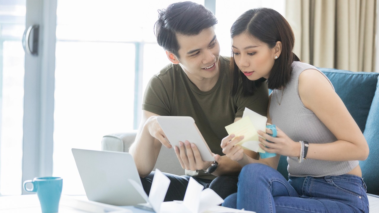 夫妇俩在看平板电脑里的帐单；图片使用于汇丰新加坡如何优化您的贷款偿还策略文章。