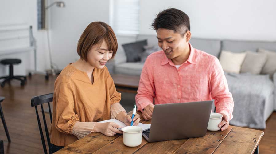 亚洲夫妇上网搜索并做笔记；图片使用于汇丰新加坡“更精明增加财富”文章。