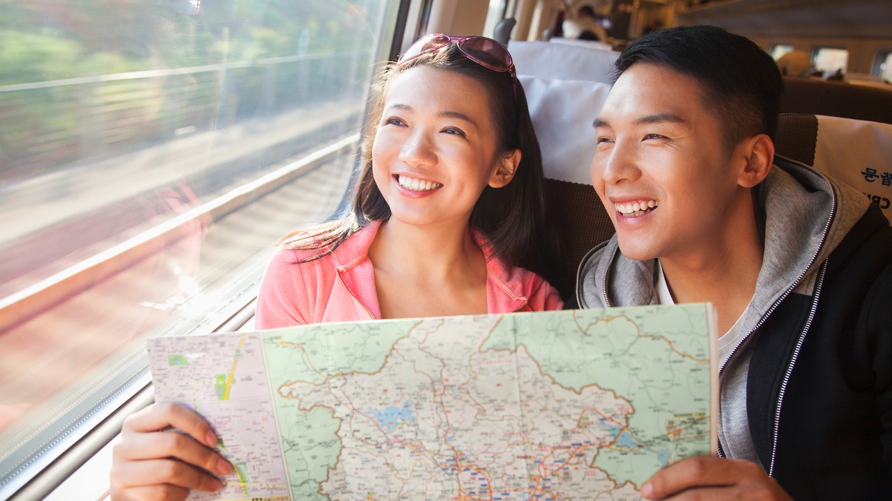 A couple is looking at a map on train.
