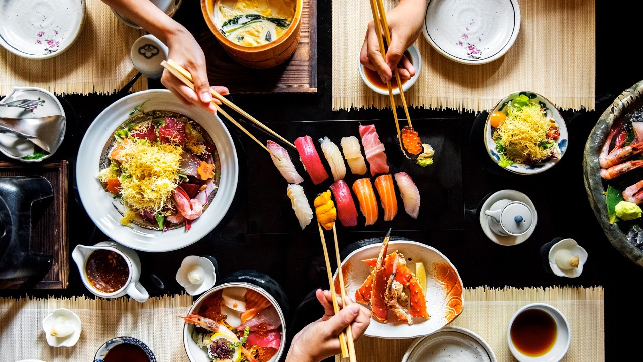 People eating food in a restaurant; image used for HSBC Singapore wine and dine rewards.