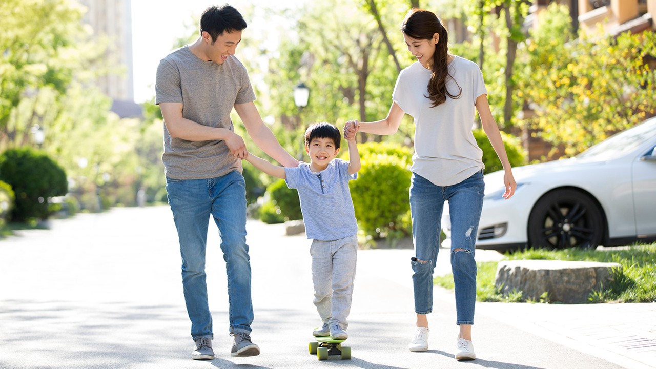 A happy young family playing with skateboard.