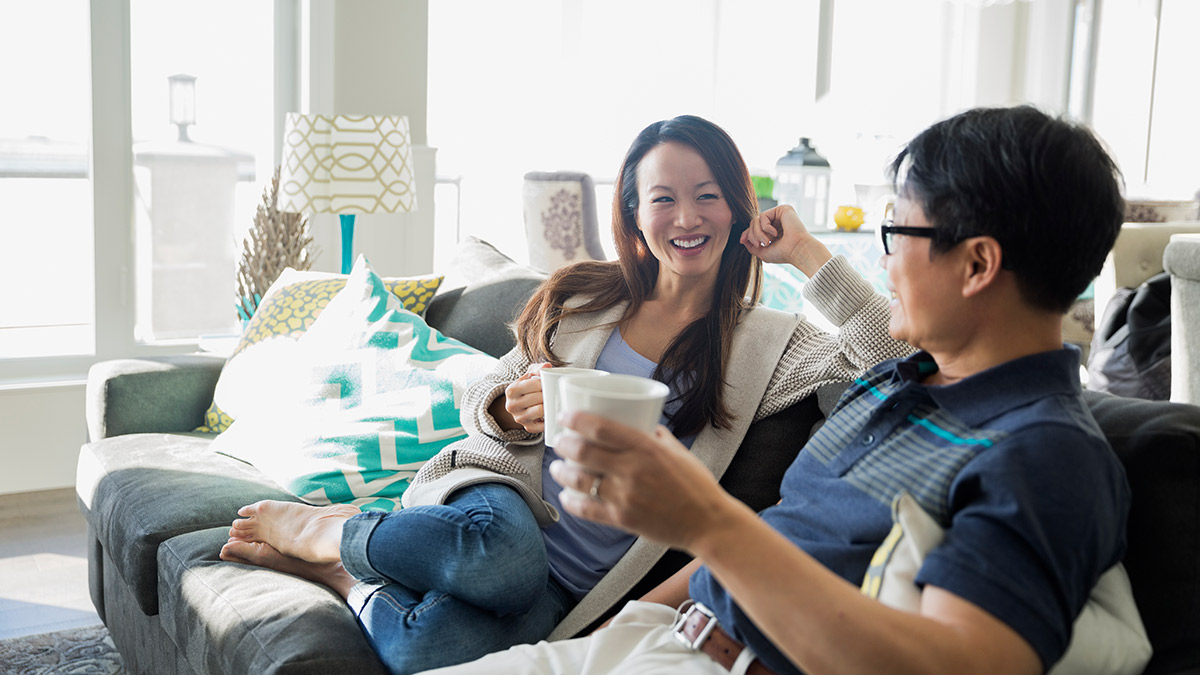 A couple is chatting on sofa; image used for Home Insurance.