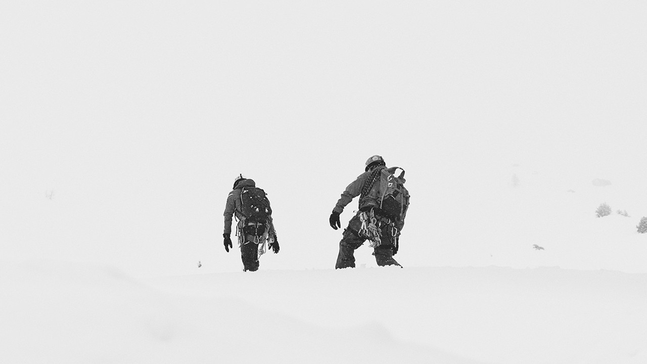 Two people climbing snow mountain.