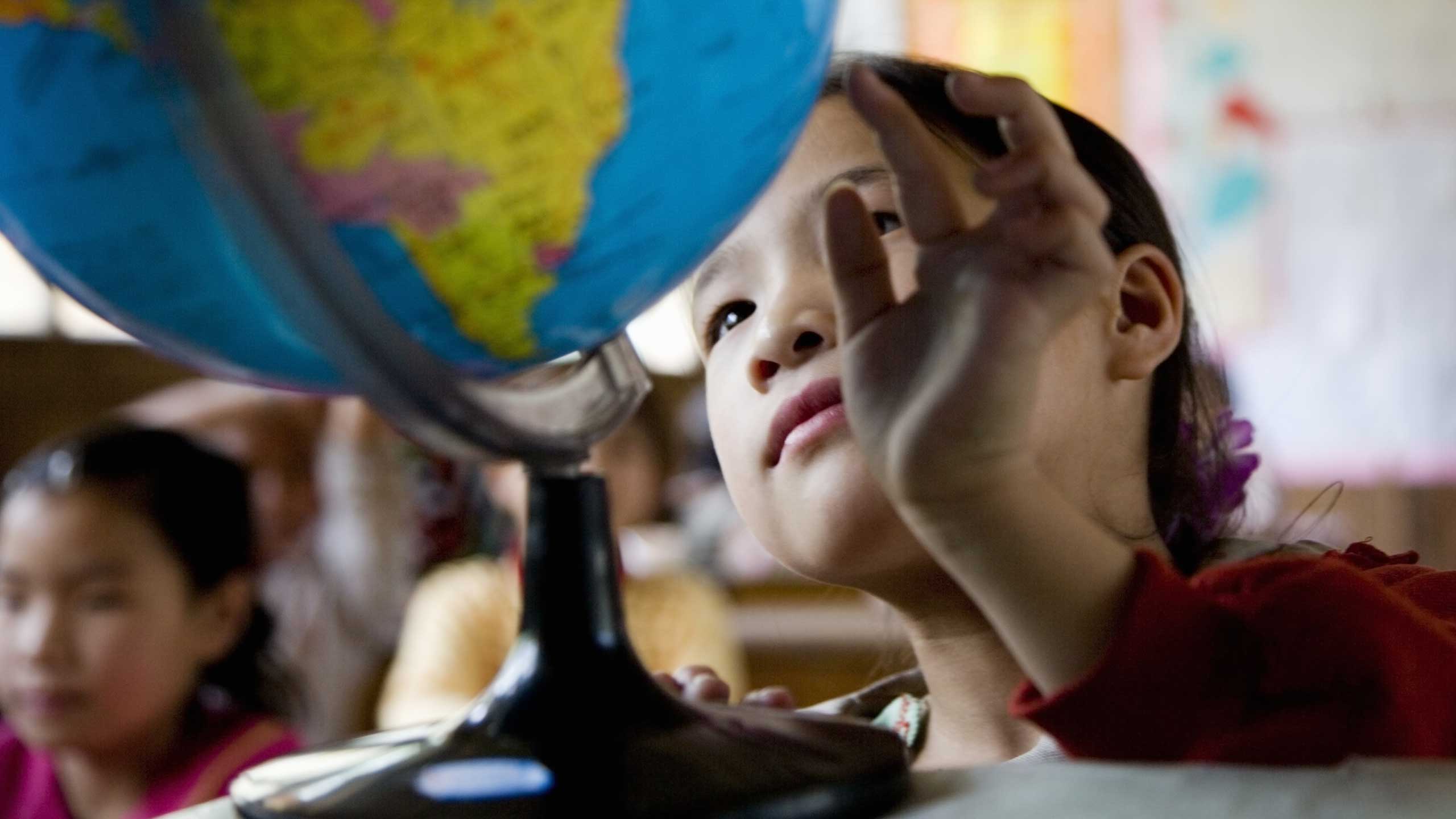 Girls looking at globe.