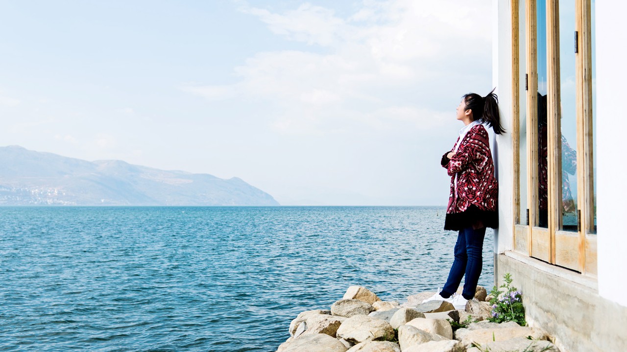 A girl is standing by the water; image used for HSBC Singapore Bonds