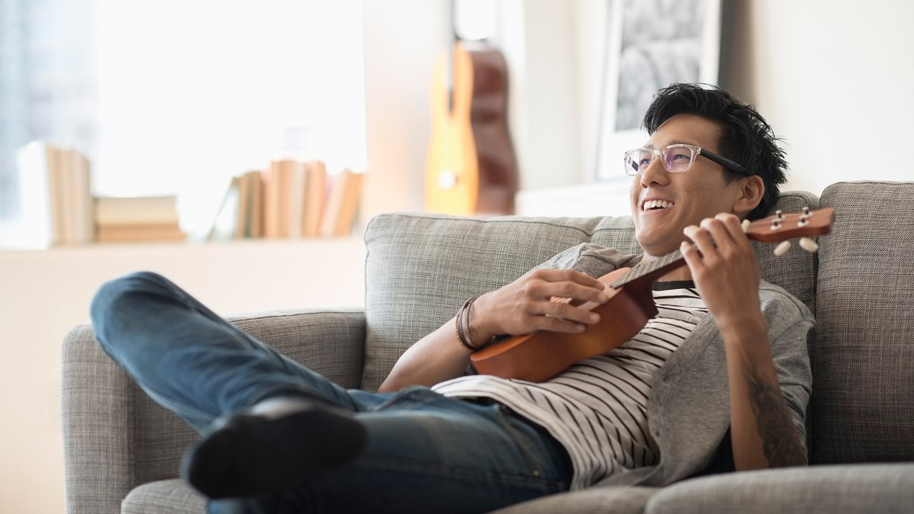 A man is playing a ukulele; Image used for HSBC Singapore Savings Promotions.