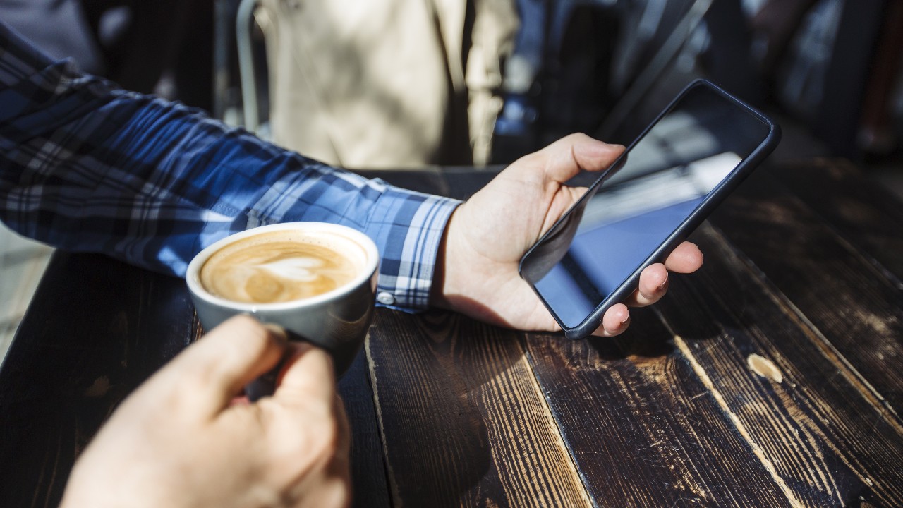 Man using smartphone in a cafe.