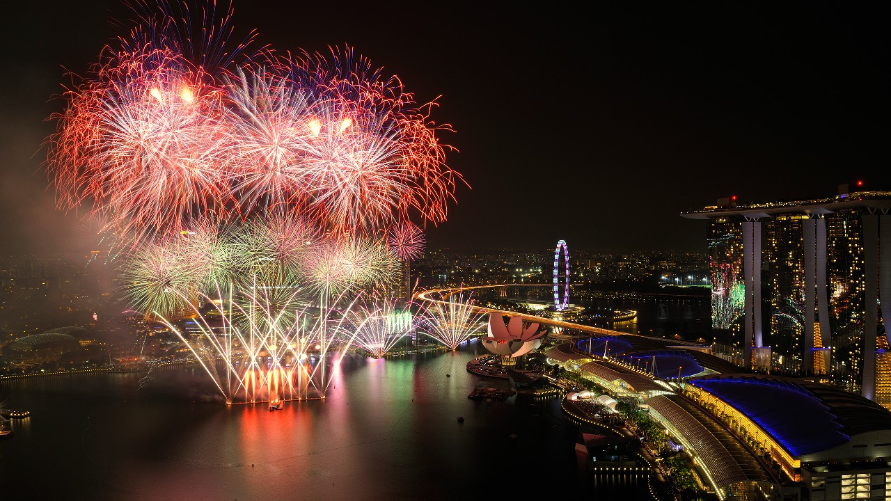 Fireworks at night over Singapore City and harbour; image used for HSBC Singapore expat article 10 must-see festivals in Singapore.