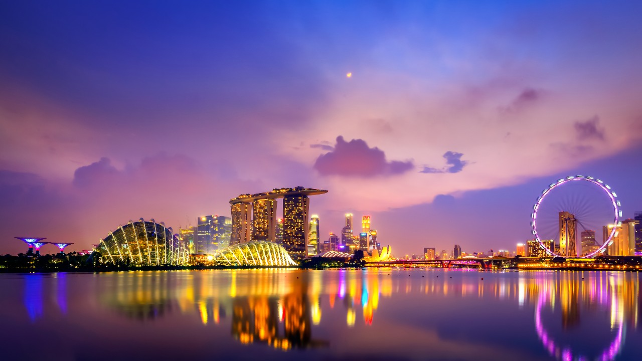 Singapore city at sunset, lights reflecting on water; image used for HSBC Singapore Expat Guidance.