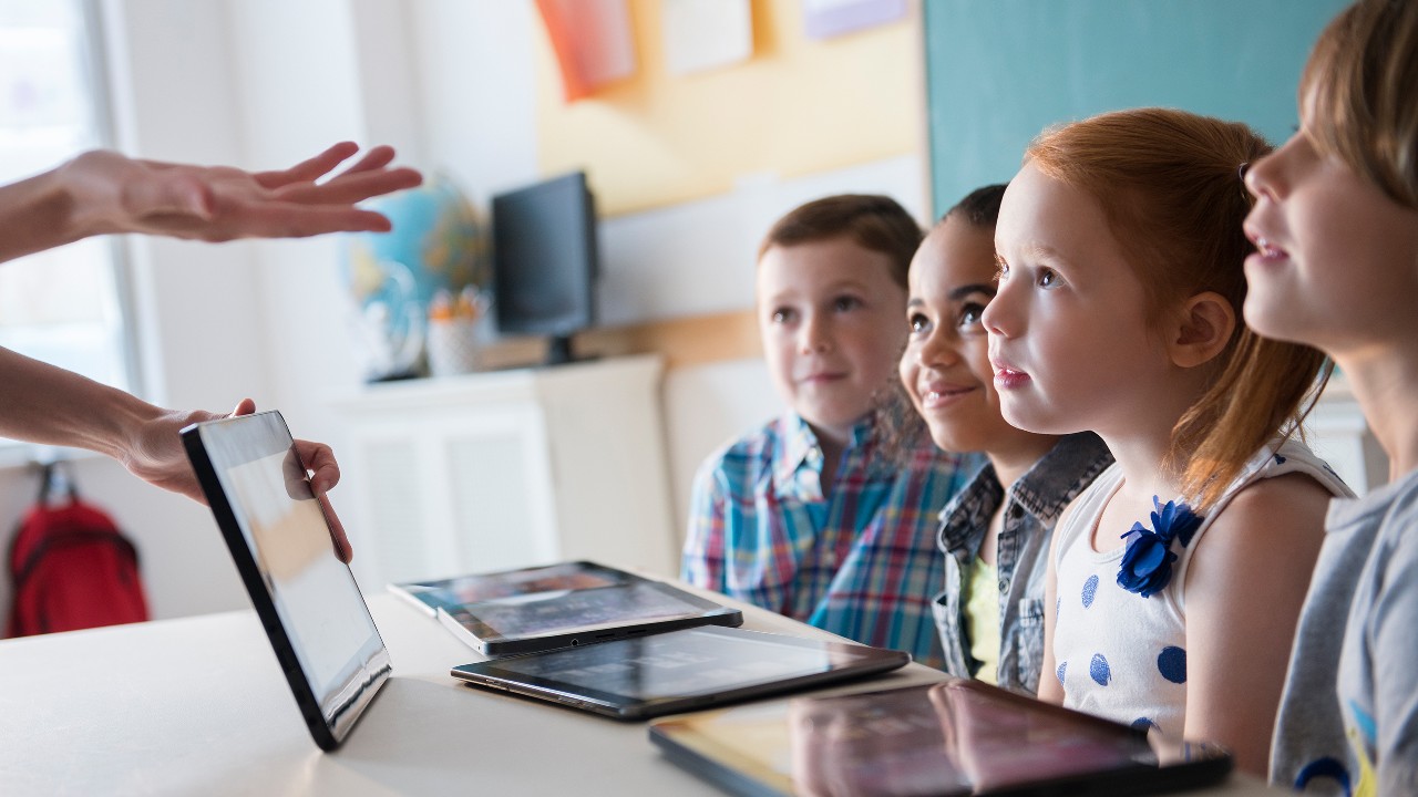 Teacher demonstrating digital tablet for students; image used for HSBC Singapore 7 considerations when choosing a school.
