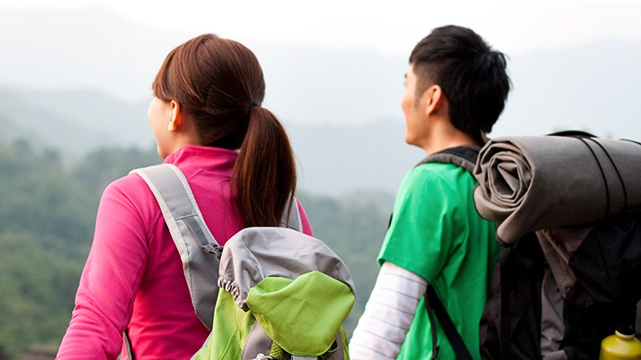 A couple hiking with heavy bags.