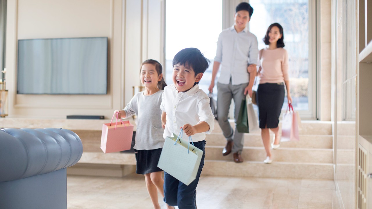 Happy family back home with shopping bags; image used for HSBC Singapore Savings step up