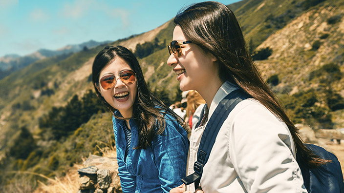 Two girls hiking with smile.