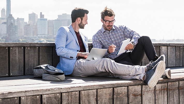 Two men are working on a rooftop; image used for HSBC Singapore International payments and finances.
