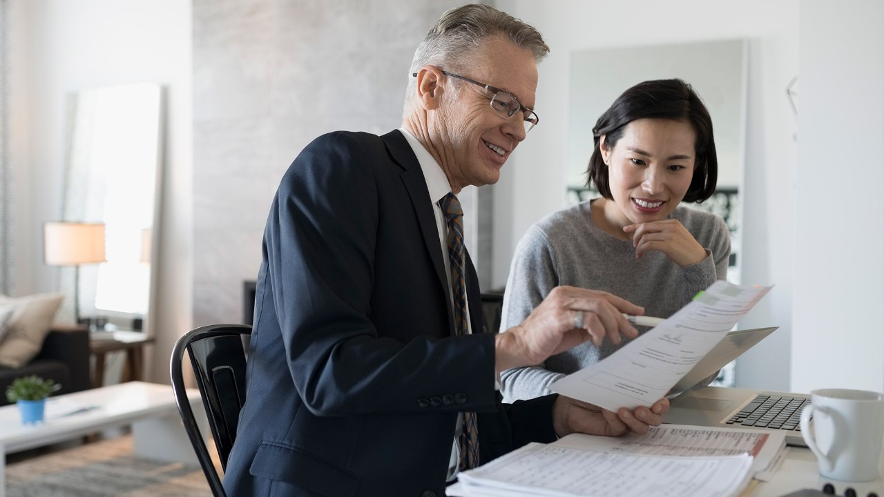 Two people are looking at papers; image used for HSBC Singapore Financial Planning