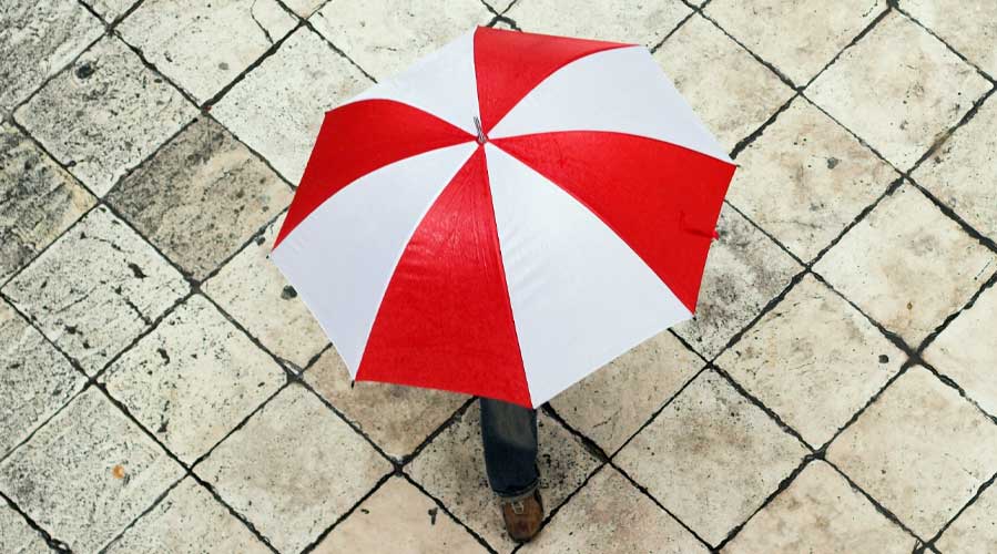 一个人撑着一把伞；图片使用于汇丰新加坡如何保障您的居所和家居财物文章。