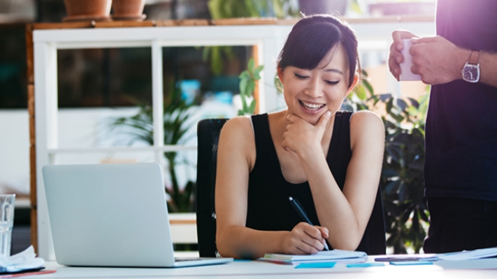 A lady is jotting notes in her seat, image used for HSBC Singapore Ways to Bank page.