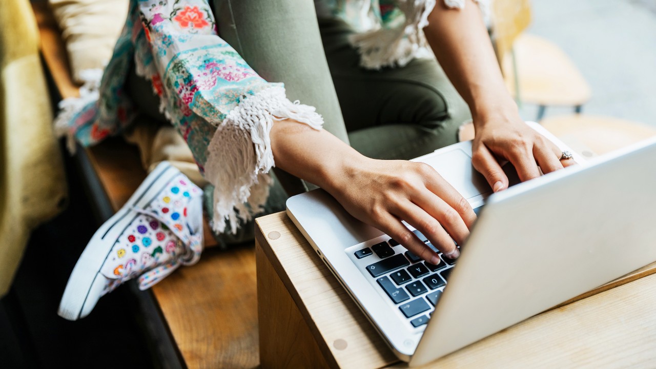 Woman sat down and using laptop.