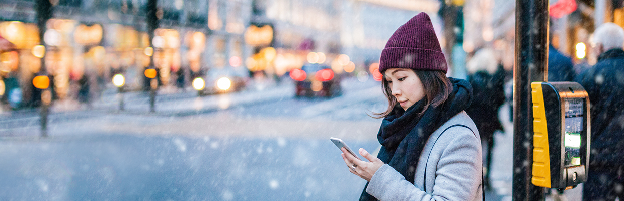 An Asian girl is using smartphone on the street;imaged used for HSBC Singapore 9 essential foreign exchange travel tips article