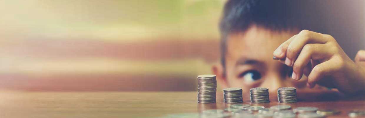 Boy stacking coins on table; image used for HSBC Singapore 4 type of investment tools you should know about article.