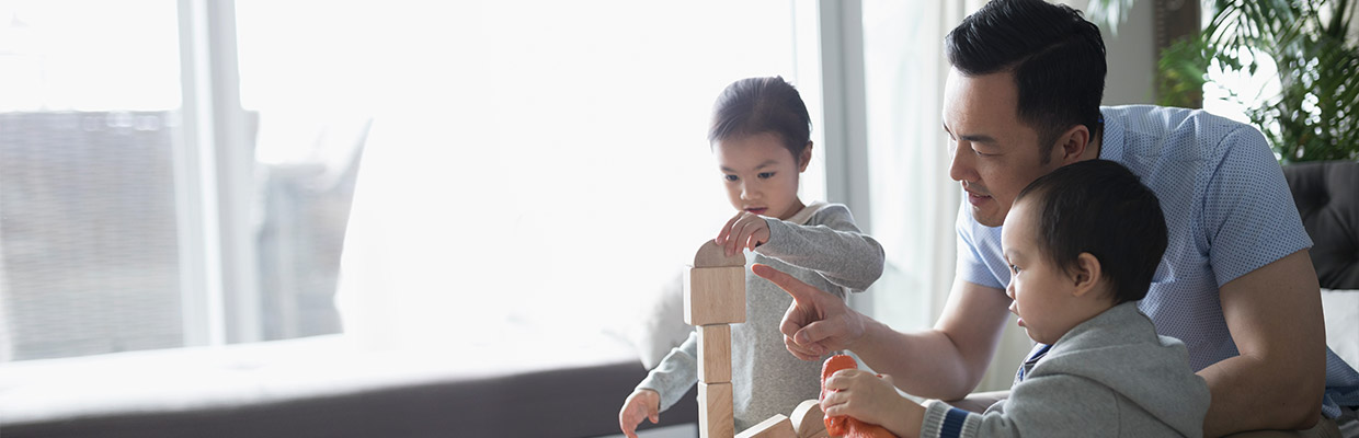 A father is playing toy blocks with kids; image used for HSBC Singapore Free Credit Bureau Report Loan Promotion page.