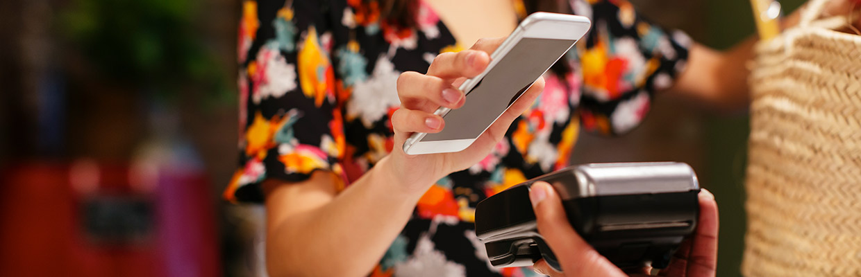 A woman is paying with her mobile phone; image used for HSBC Singapore Debit Card