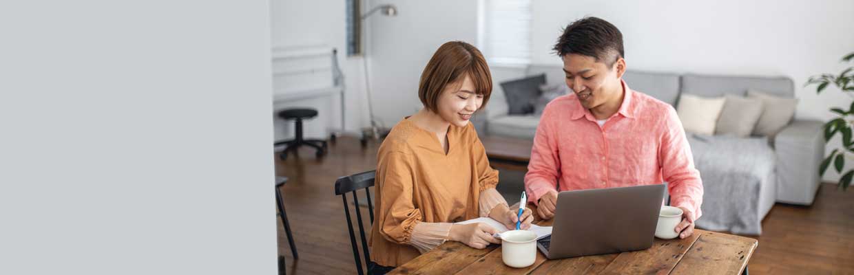 Asian couple searching on internet and making notes; image used for HSBC Singapore Smarter ways to grow your cash article.