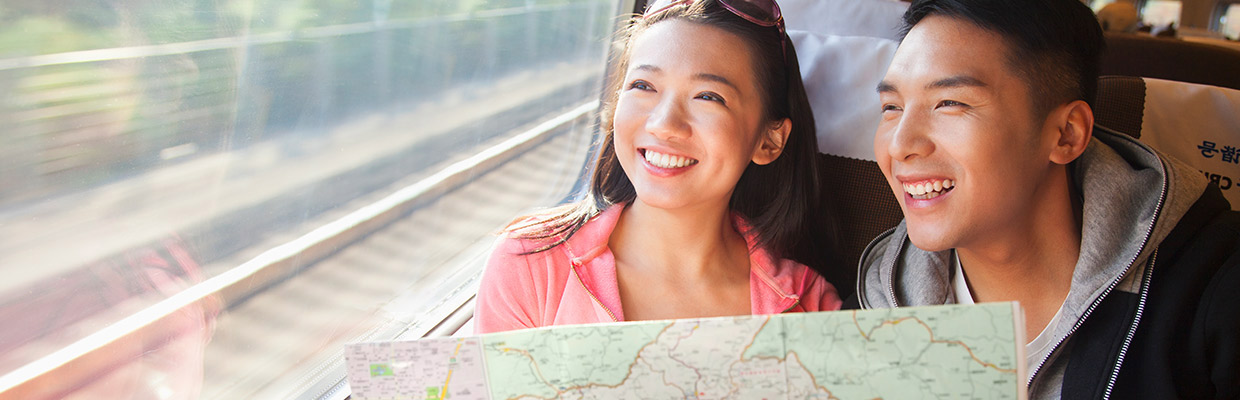 一对夫妇在火车上查看地图；图片使用于汇丰国际医疗保险。