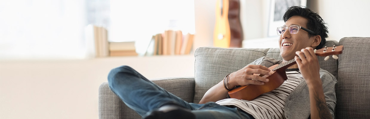 A man is playing a ukelele; image used for HSBC Singapore Deposits and Debit Card Promotions