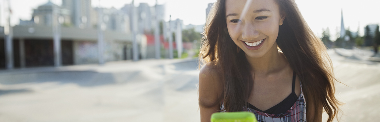 拿着手机微笑的姑娘；图片使用于汇丰新加坡个人信用循环贷款自动充值