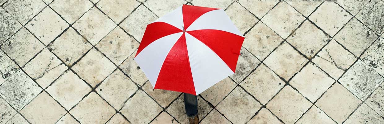 A person holding an umbrella; image used for HSBC Singapore How to protect your home and everything in it article.