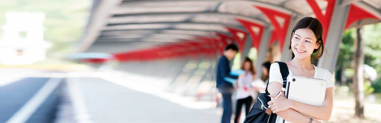 A university student holding laptop; image used for HSBC Singapore Planning your child's education.