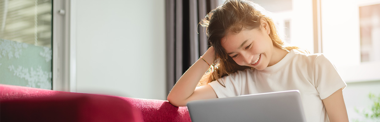 Woman looking at laptop; image used for HSBC Singapore fees rewards.