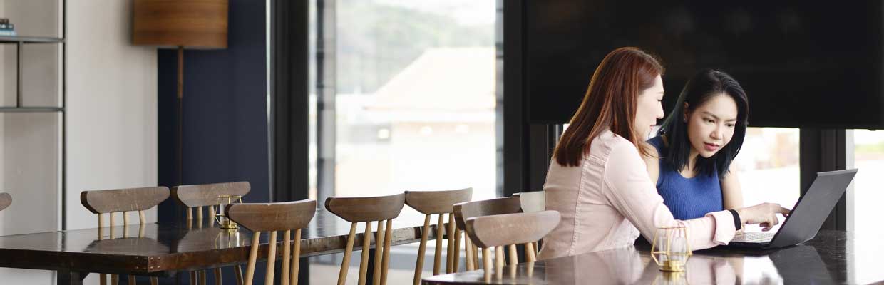 Two women working on a laptop; image used for HSBC Singapore Strategic financial planning.