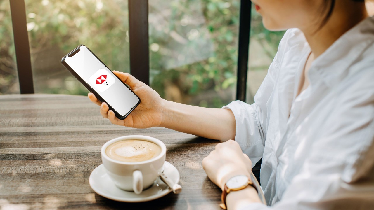 Woman looking at HSBC Singapore app on mobile.