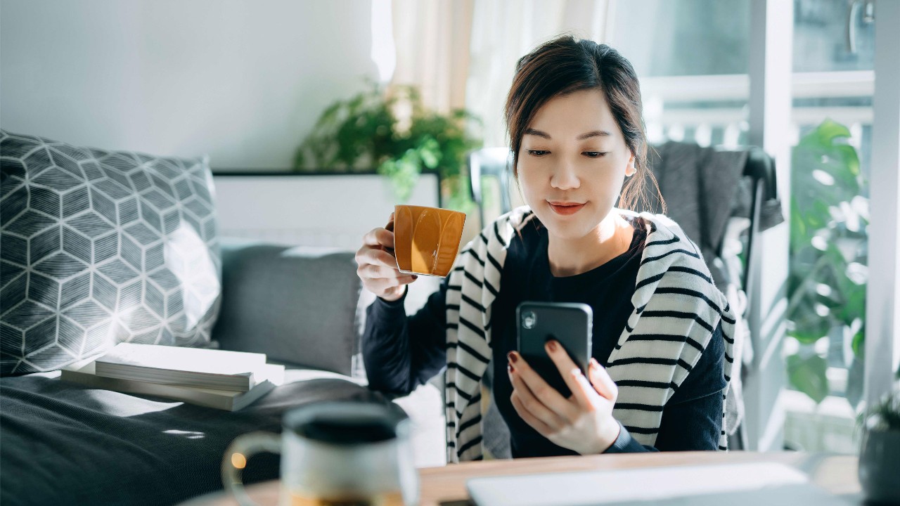 A woman using mobile to shop online at home.