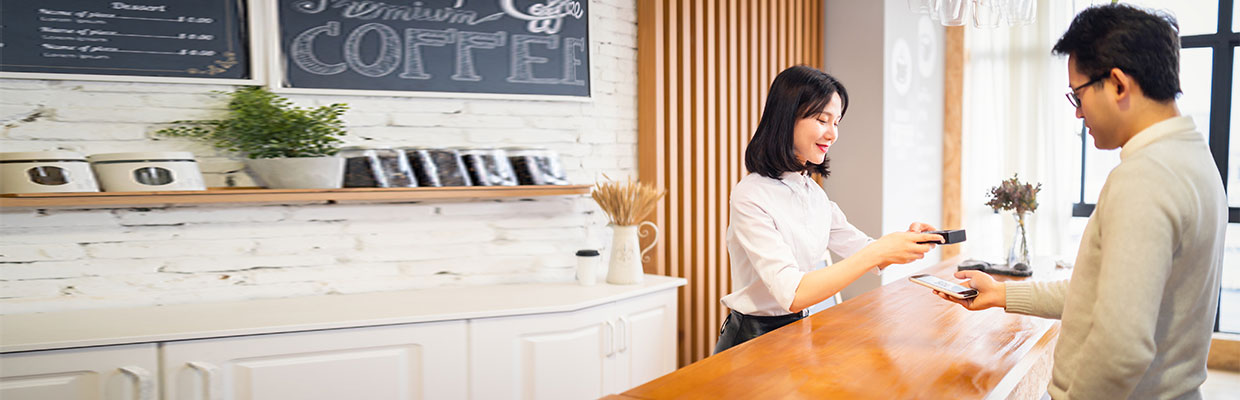 Mobile payment in a coffee shop; image used for Google Pay with HSBC Credit cards.