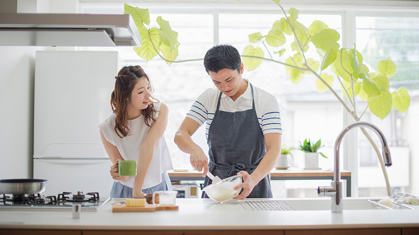 Couple in kitchen making food