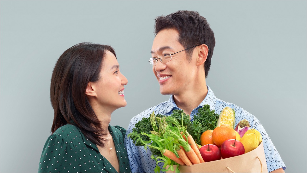 A couple holding groceries 