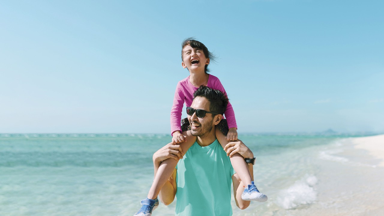 A girl enjoying piggyback ride on father