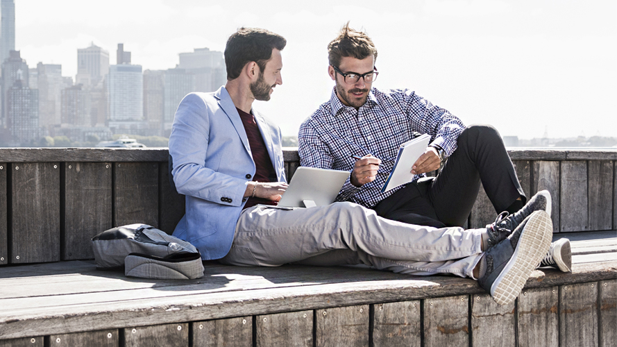 Two men are working on a rooftop; image used for HSBC Singapore International payments and finances.