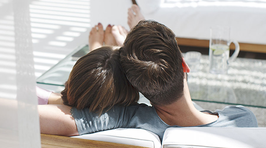 A couple is realxng on a sofa; image used for HSBC Singapore partner offers.