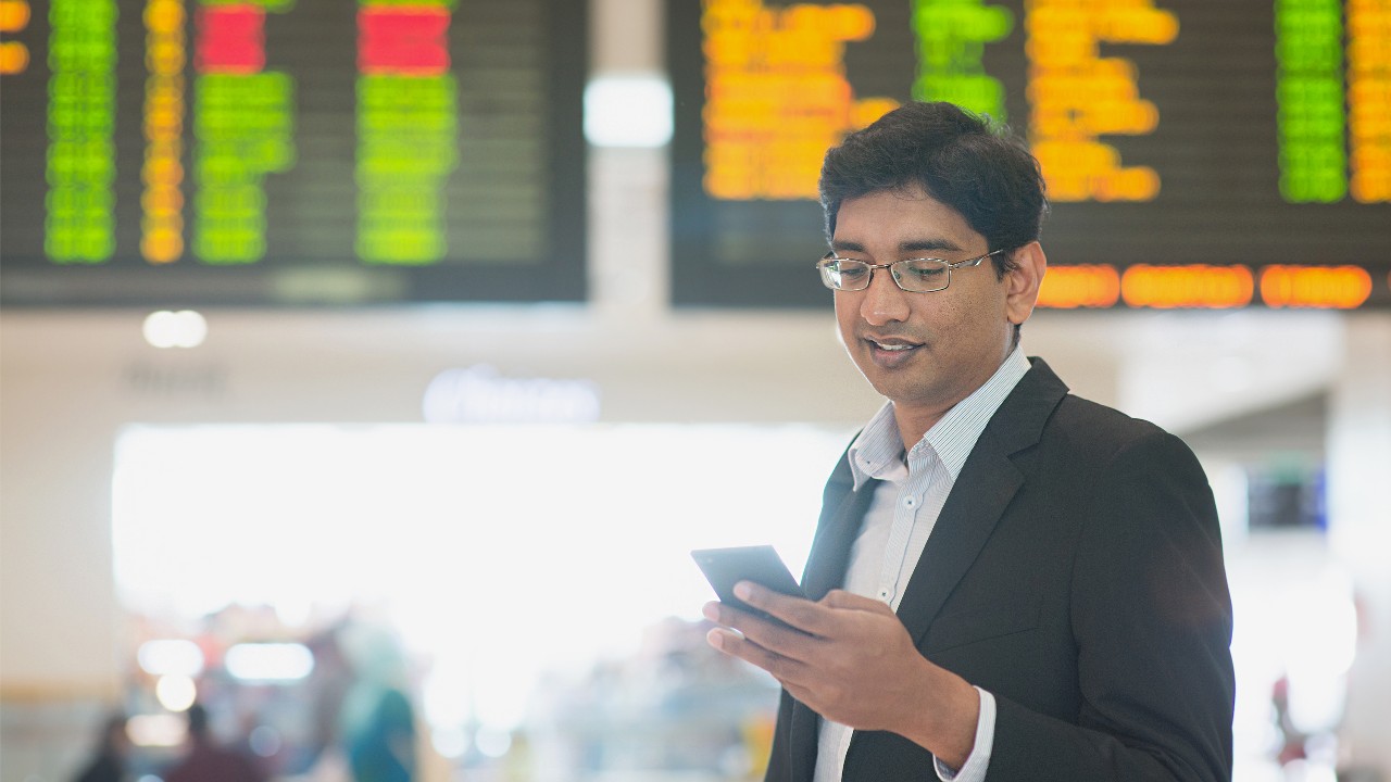 Man checking his phone ; image used for HSBC Singapore International executives.